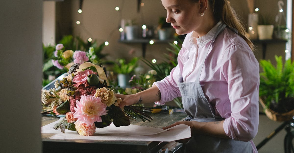 Woman florist creating a beautiful flower bouquet in a cozy indoor setting.